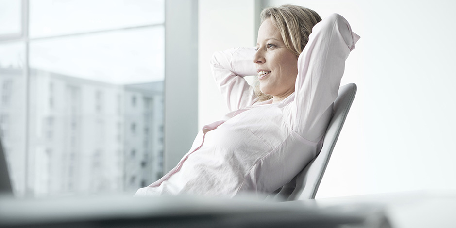 businesswoman relaxing behind desk